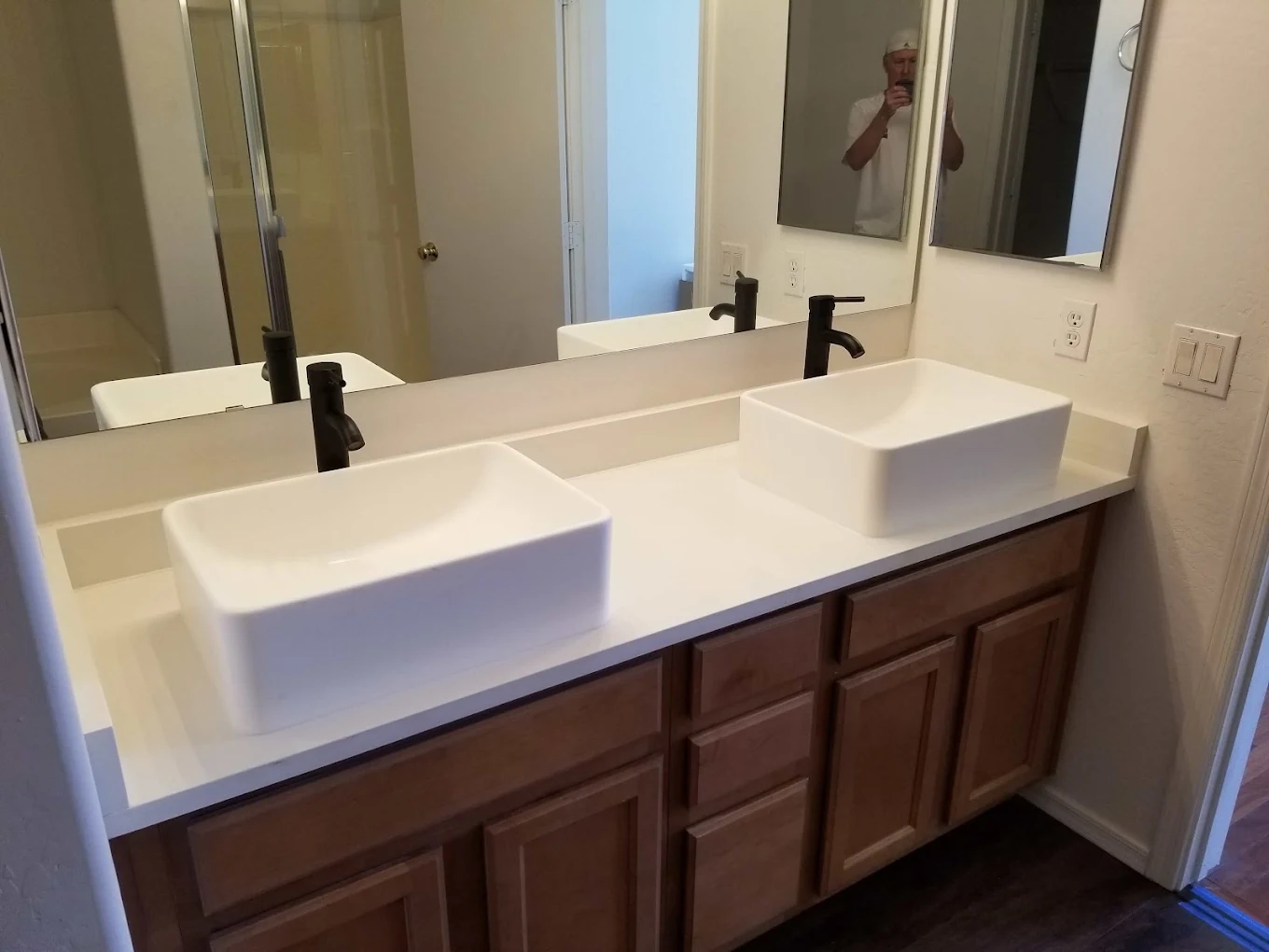 Modern bathroom vanity with two white rectangular vessel sinks and black faucets