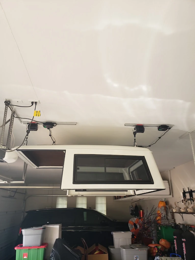 Garage interior with mounted electronic door openers and hardware systems installed on ceiling
