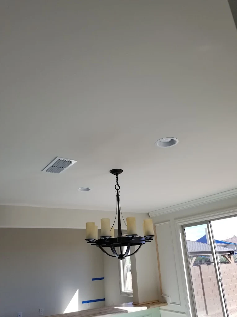 Modern ceiling with recessed lights, pendant chandelier, and open floor plan with glass doors
